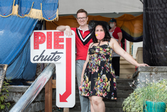 Two people stand to the right of a sign that reads, "Pie Chute."
