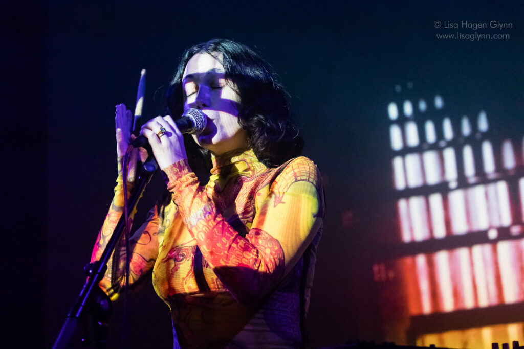 Kelly Lee Owens closes her eyes while singing