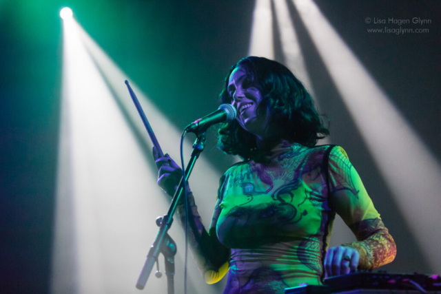 Kelly Lee Owens sings while holding a drumstick