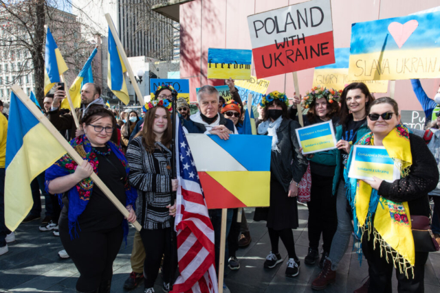 A group carries signs and flags in support of Ukraine.