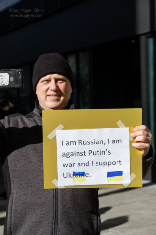 A person carries a sign that reads, "I am Russian, I am against Putin's war and I support Ukraine."