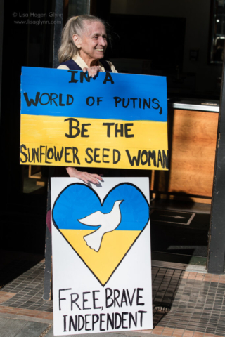 Signs read, "In a world of Putins, be the sunflower seed woman," and "Free, brave, independent"