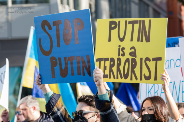 Signs read, "Stop Putin" and "Putin is a terrorist"