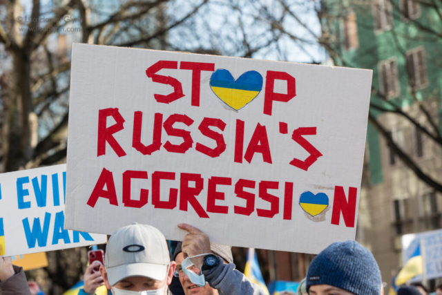 A sign reads, "Stop Russia's aggression"