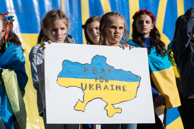 Two children hold a sign that reads, "Pray for Ukraine"