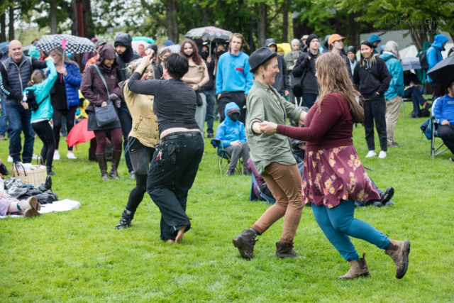 Attendees dance in the rain at the Mural Amphitheatre