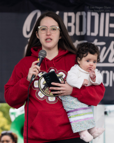 A rally speaker holds a child