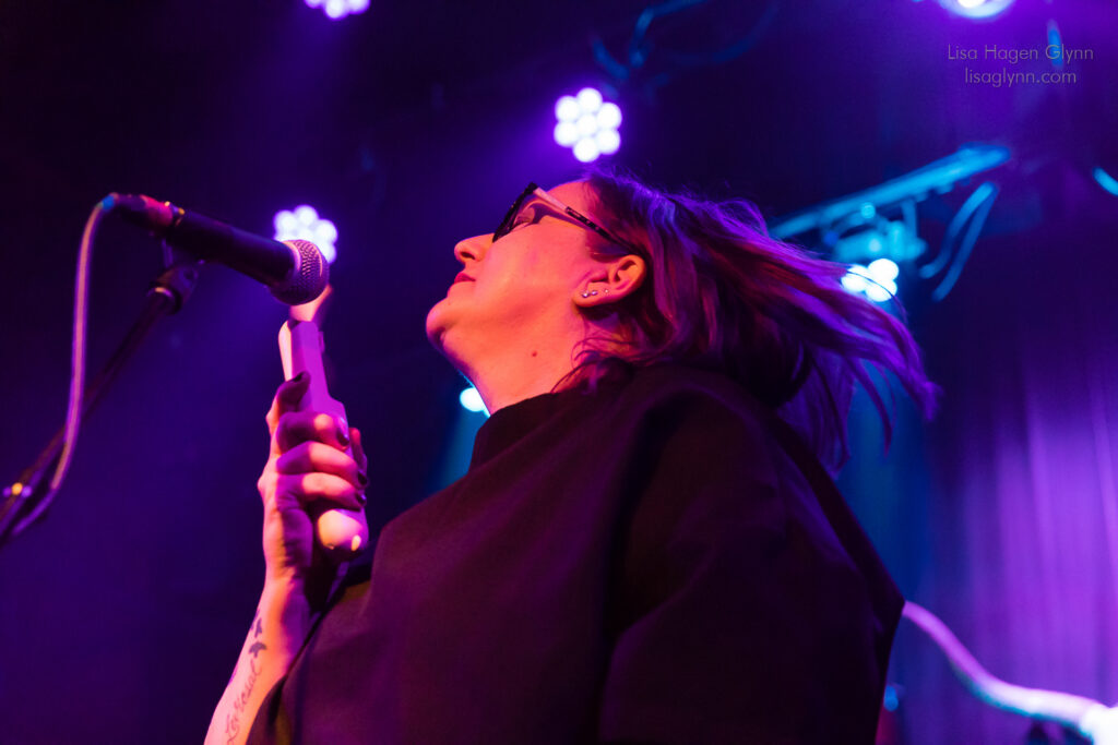 Carrie Akre uses a pink "menopause fan" onstage.